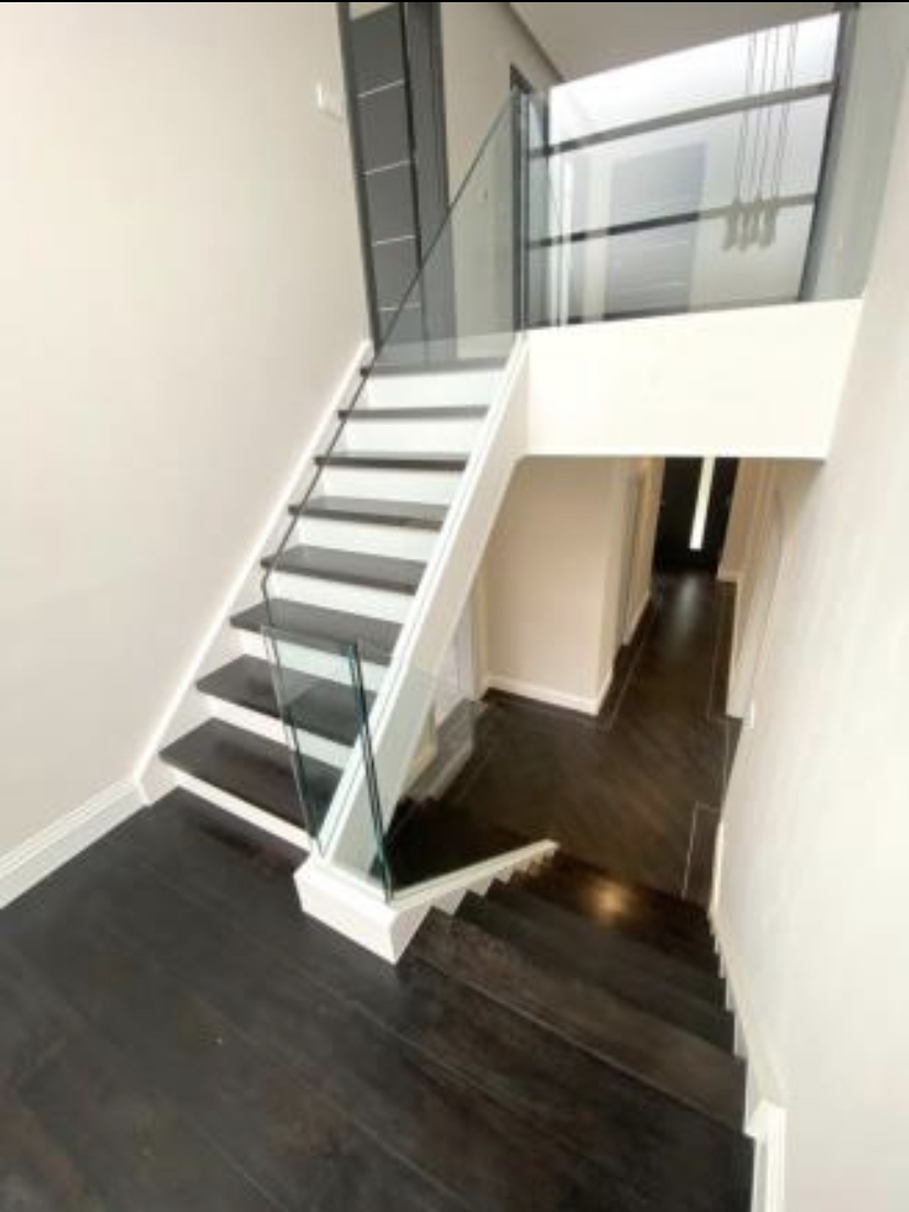 U-shaped stairs with glass balusters
