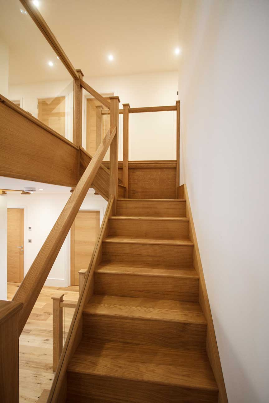 contemporary L-bent staircase with glass balusters