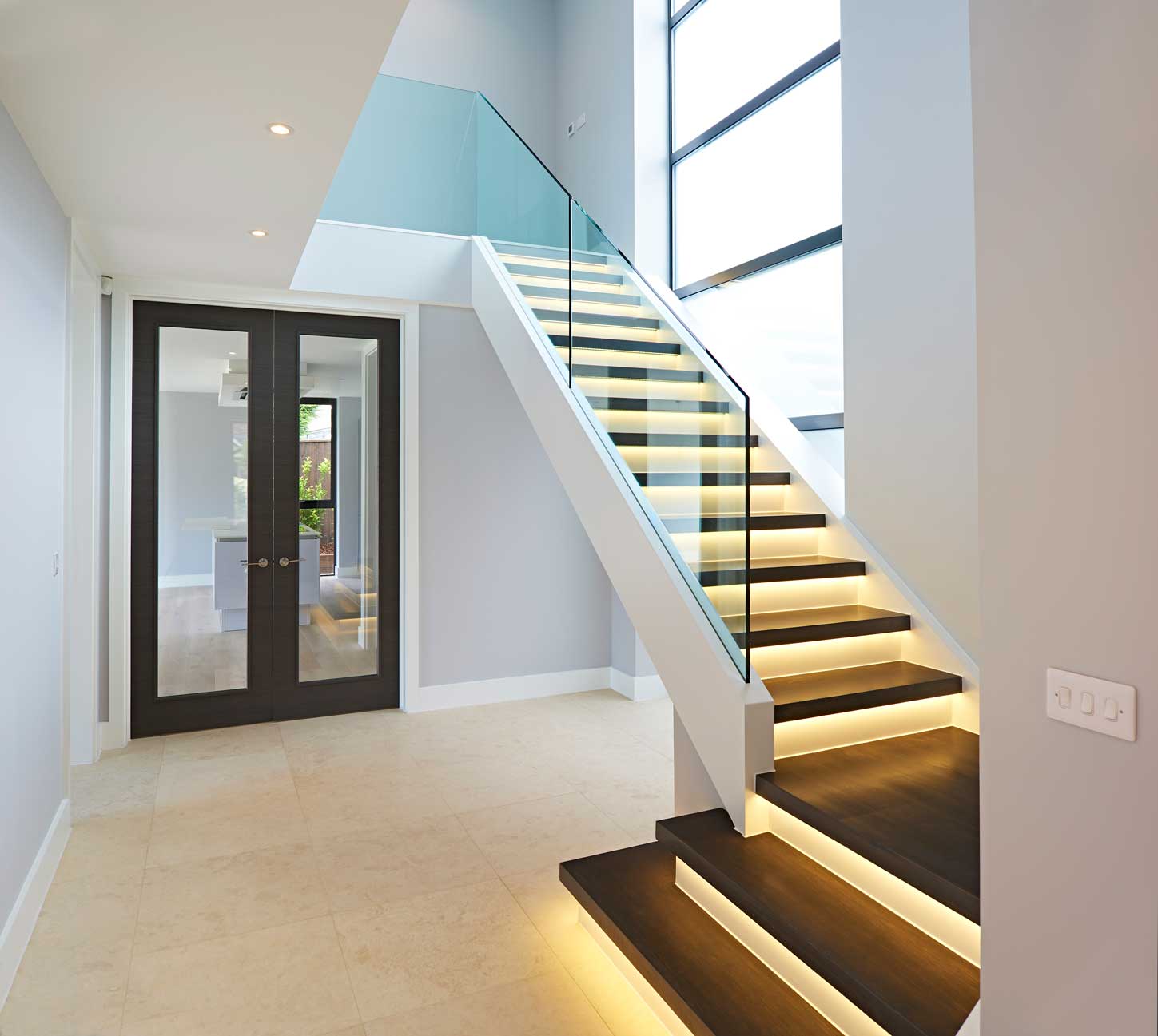 modern L-bent staircase with lights and glass balusters